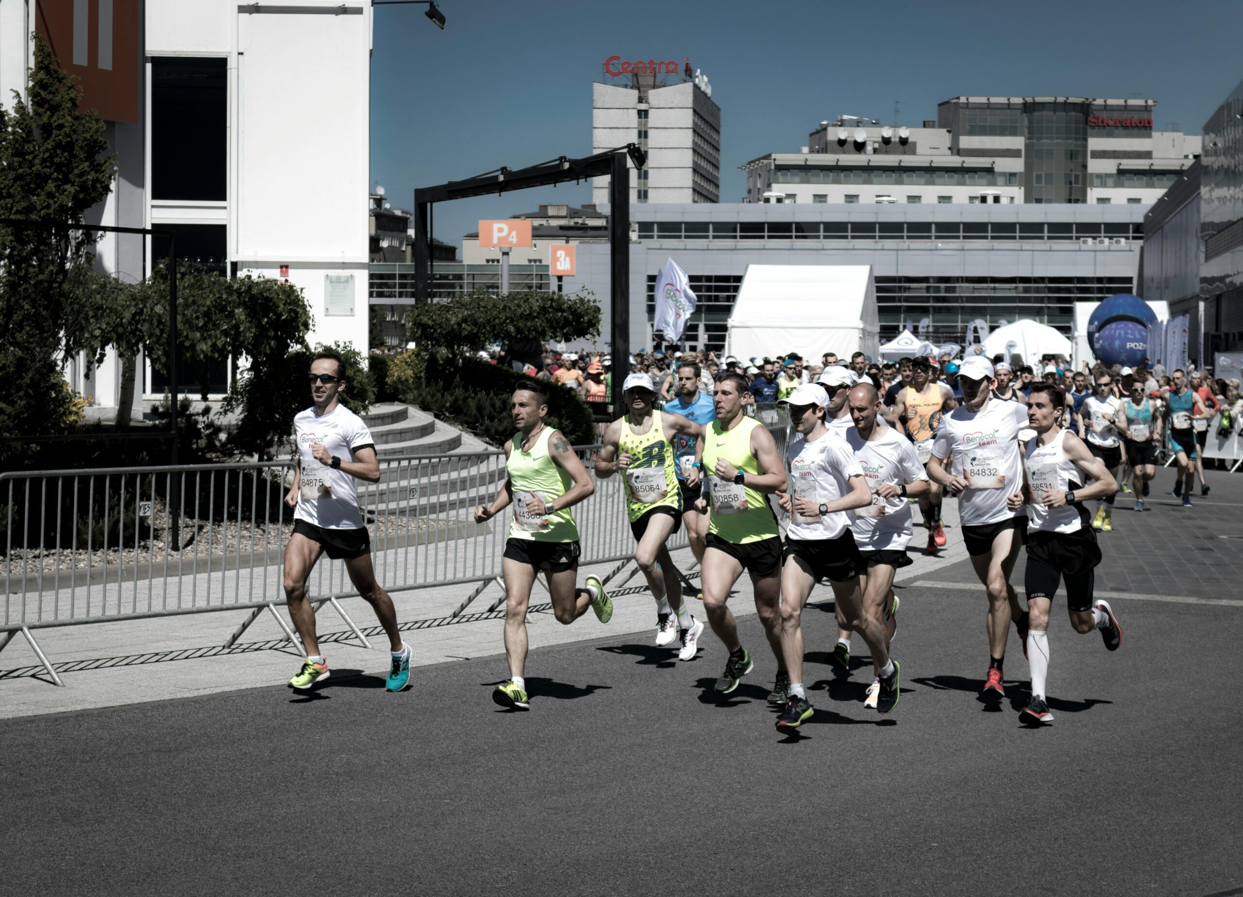A group of diverse runners competing in an urban marathon on a sunny day.